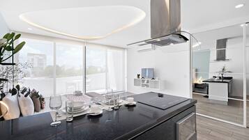 Una cocina moderna con encimera negra, electrodomésticos de acero inoxidable y un ventanal grande.