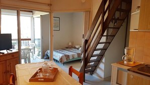Un espace de vie compact comprenant un coin repas, une chambre et une cuisine.