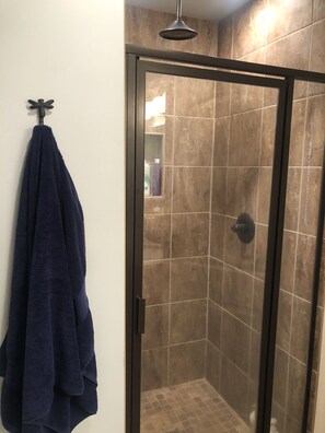 Enjoy a refreshing shower in this bathroom with a glass-enclosed shower area and handheld showerhead.