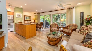 A spacious living area with a kitchen, dining area, and a large sliding glass door to the outdoors. - Hale Hui Kai 102 on Keawakapu Beach (Kihei)