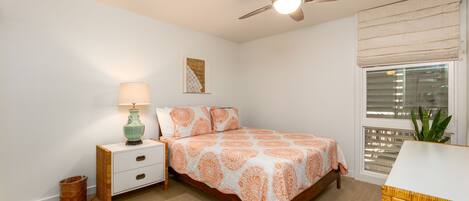A bedroom with a bed, nightstand, lamp, ceiling fan, and window with blinds.