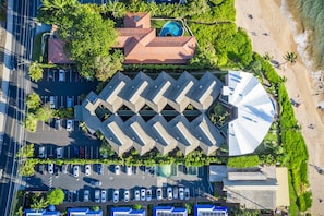 Vue aérienne d’un hôtel avec une piscine, un parking et un accès à la plage.