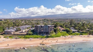 A beachfront hotel with multiple buildings, a sandy beach, and clear blue waters. - Hale Hui Kai 304 Two bedroom Two bath with AC and Ocean views (Kihei)
