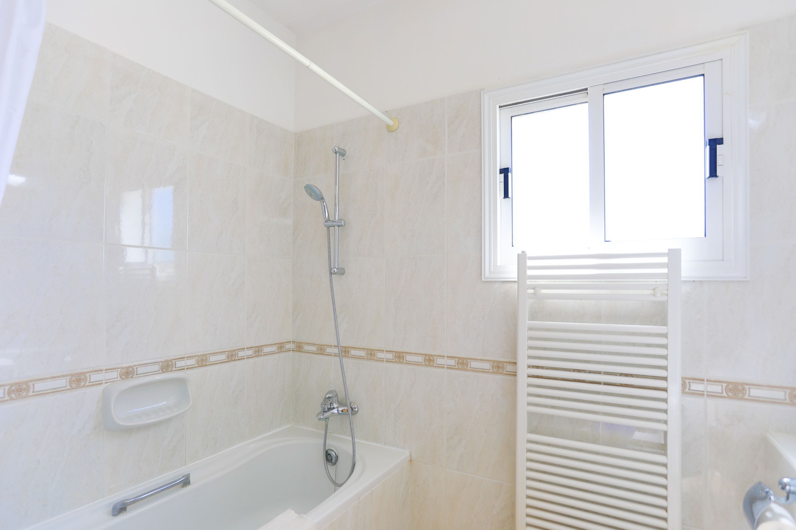 A bathroom with a bathtub, a shower, and a window.