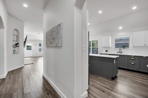 A modern kitchen with grey cabinets, a central island, and a view of the outdoors.