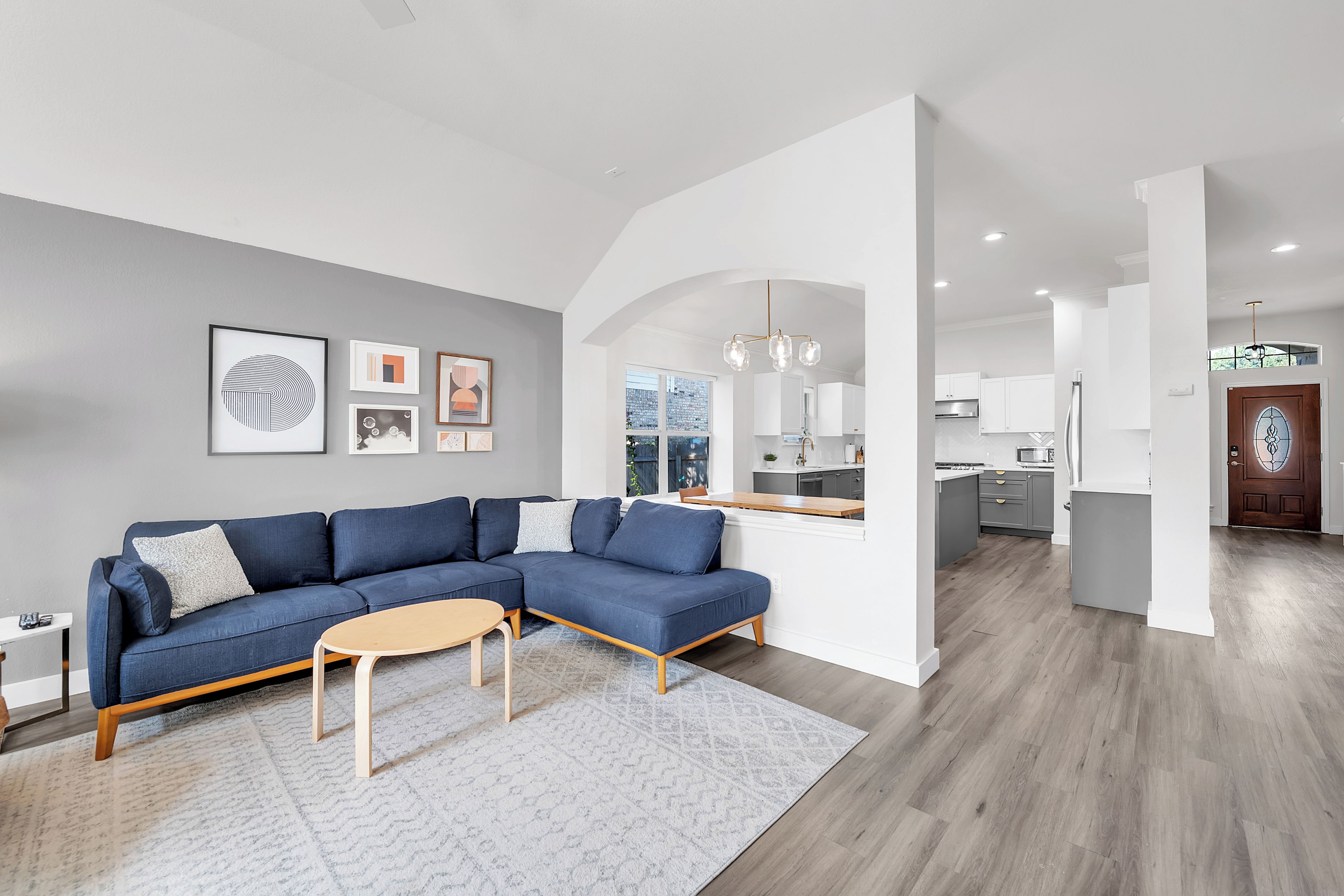 A modern living room with a sectional sofa, a coffee table, and a rug.