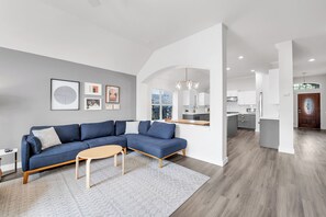 A modern living room with a sectional sofa, a coffee table, and a rug.