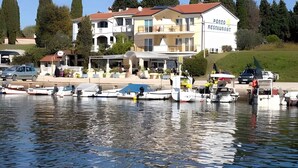 A waterfront property with a restaurant named "DOXO RESTAURANT" and several boats docked in the water. - Studio with balcony and air conditioning (Savudrija)