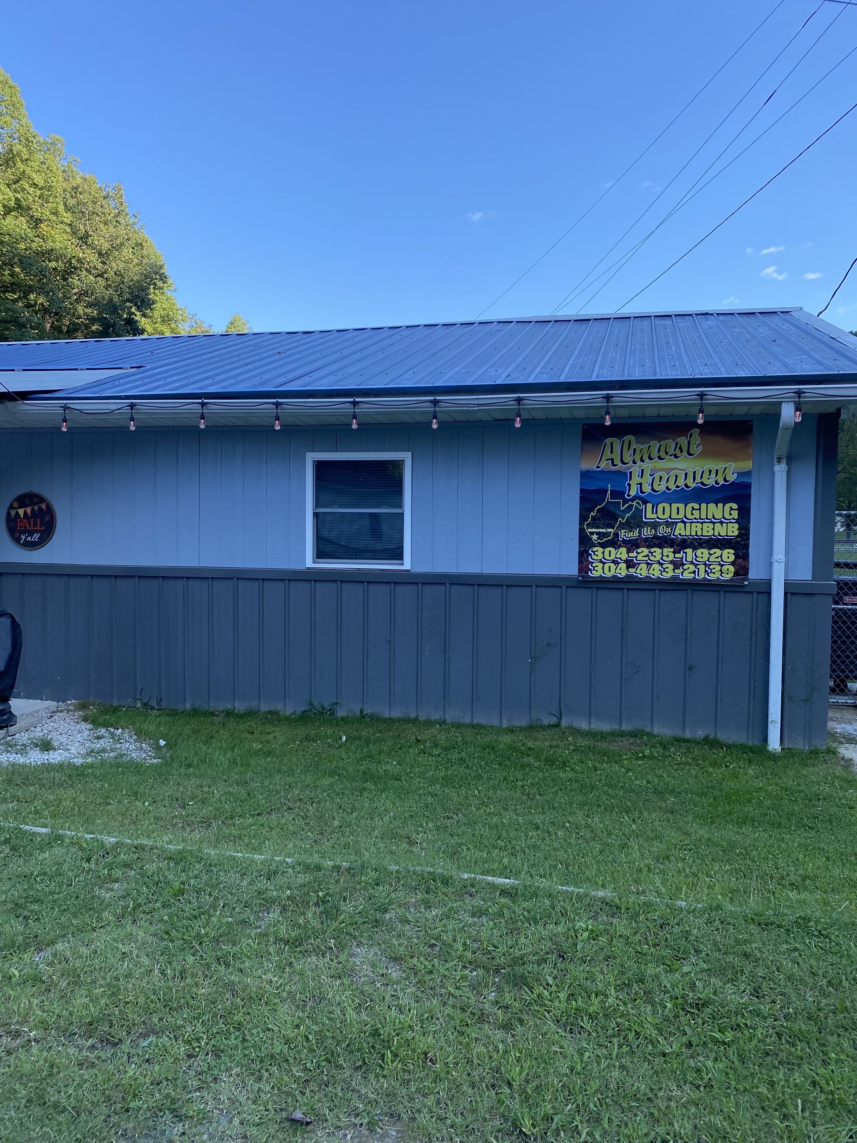 A small building with a metal roof, a window, and a sign advertising lodging availability.
