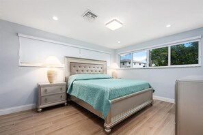 A bedroom with a bed, nightstands, a window, and a ceiling light. - Beach House: Walk 2 Blocks to Beach & Pet Friendly (Hutchinson Island)