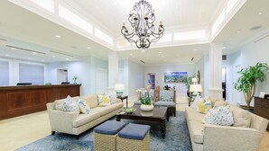 A spacious lobby with a chandelier, two sofas, a coffee table, and a reception desk. - Ritz Carlton Club ST. Thomas - 2 Bedroom 2 Bath Suite- Premier Resort (St Thomas)