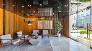 Un interior moderno con una zona de estar, una planta en maceta y vista a la calle.