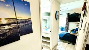 Een gang met zicht op een slaapkamer, een badkamer en een woonruimte.
