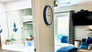 Een moderne badkamer met een grote spiegel, een witte wastafel en een handdoekrek.
