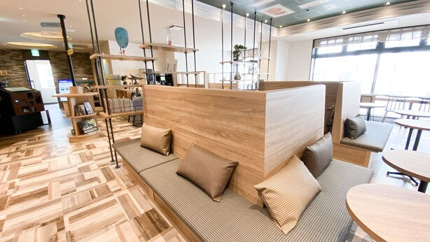 A modern interior with a wooden reception desk, seating area, and a view of the outside. - Comfort Hotel Takamatsu (Takamatsu)