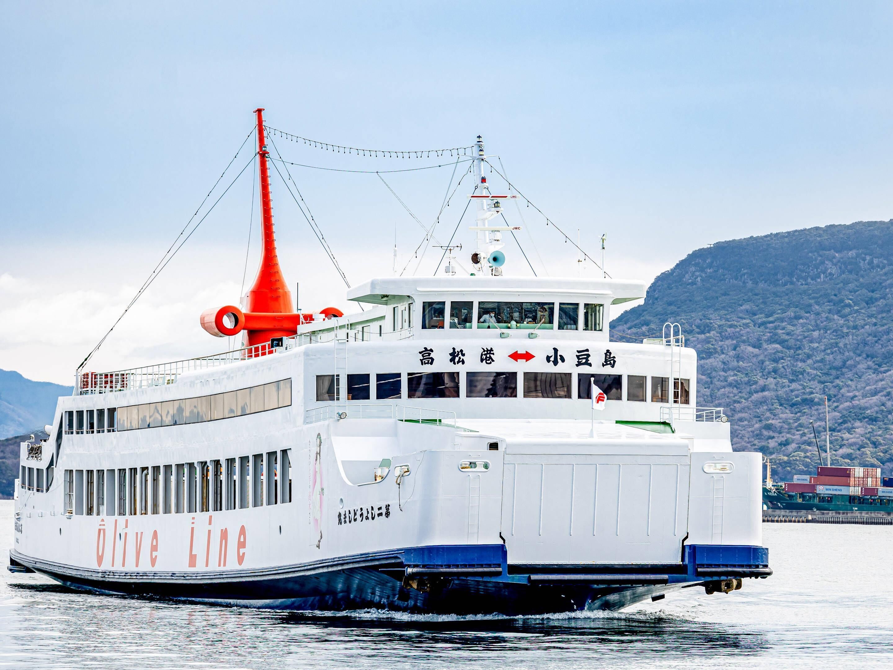 Een witte veerboot met rode schoorstenen, een hut met ramen en een dek.