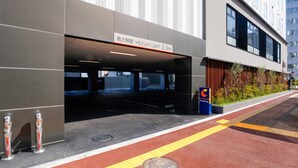 A modern building with a height limit sign, a parking sign, and a red tactile paving path. - Comfort Hotel Takamatsu (Takamatsu)