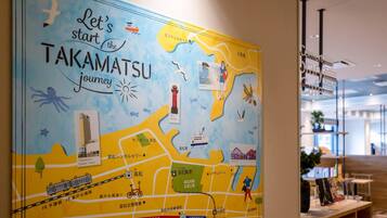 Un mapa colorido de Takamatsu que muestra lugares emblemáticos y rutas de transporte.