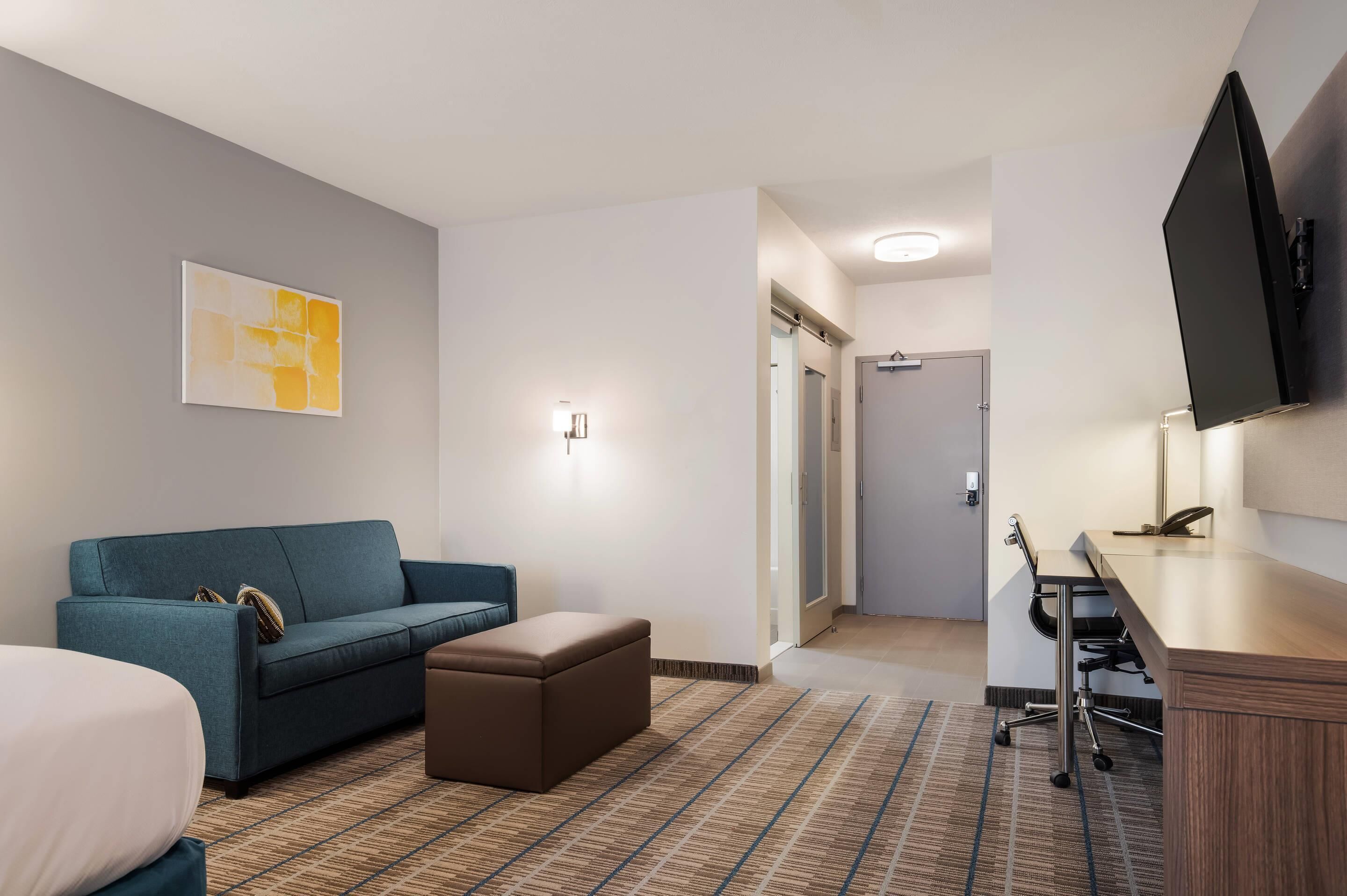 desk, laptop workspace, iron/ironing board, bed sheets