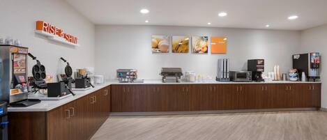 A modern kitchen with a central island, equipped with a coffee machine, microwave, and toaster.