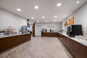 Eine moderne Küche mit Frühstücksbar, ausgestattet mit Kaffeemaschine, Toaster und Kühlschrank.