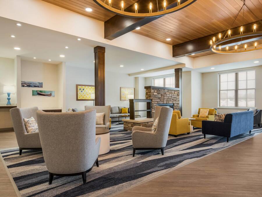 A spacious living area with modern furniture, a stone fireplace, and a large window providing natural light.