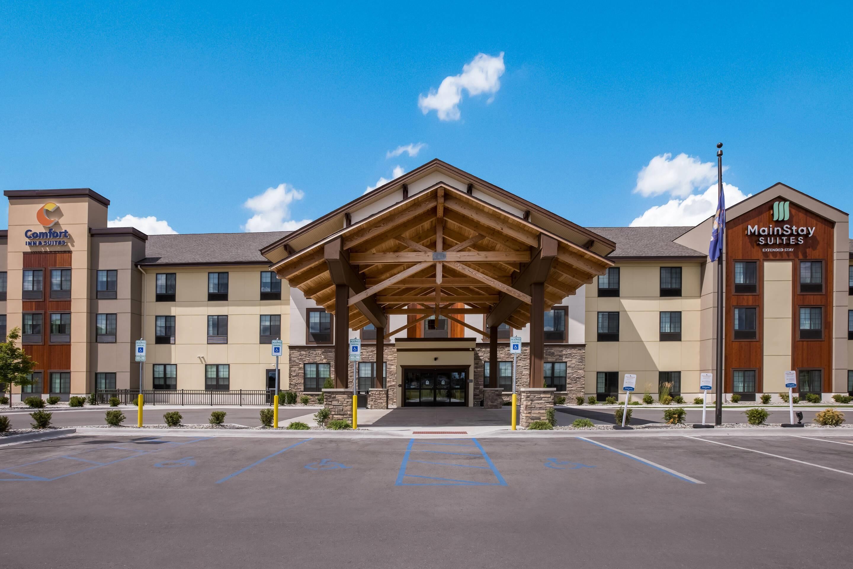 A hotel with a covered entrance, multiple floors, and a parking lot with handicapped parking spaces.