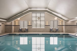 Una piscina techada, sillones reclinables de piscina
