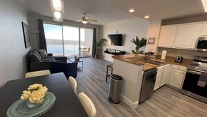 Un appartement moderne doté d’un coin repas, d’une cuisine et d’un balcon avec vue.