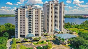 Un hôtel de grande hauteur, avec de nombreux étages, un parking et une vue sur un lac.