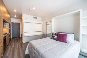 A modern hotel room with a large bed, a wardrobe, a desk, and a mirror. - Canyon Haus 309 (Park City)