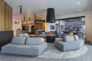 A modern living area with sofas, a fireplace, and a view of a bar area.