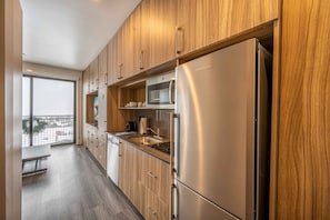 A full kitchenette with all new appliances includes a full sized dishwasher, microwave, fridge/freezer, and a 2 burner stove