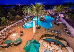 A swimming pool with lounge chairs and umbrellas, surrounded by palm trees and a tiled deck. - Beautiful Home! 3 Bikes & 6-Seater Golf Cart! Steps to the Pool! - Out with the Tide, Highland Parks (Santa Rosa Beach)