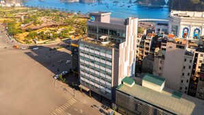 A high-rise hotel with a modern design, located near a coastal area with views of the sea and rocky islands. - Tru by Hilton Ha Long Hon Gai Centre (Hong Gai)