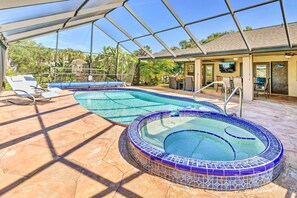 A covered outdoor swimming pool with lounge chairs and a hot tub. - Port Charlotte Retreat w/ Heated Pool & Spa! (Port Charlotte)
