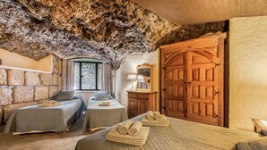 A room with a stone ceiling, two beds, a wooden wardrobe, and a large door. - Pet-friendly Villa Finca Toledo with Pool, Terrace, Garden, A/C & Wi-Fi (San Miguel de Abona)