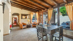 A spacious room with a wooden ceiling, a dining table, wicker chairs, and a view of the outside. - Pet-friendly Villa Finca Toledo with Pool, Terrace, Garden, A/C & Wi-Fi (San Miguel de Abona)