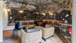 A cozy interior with stone walls, wicker furniture, and a fireplace. - Pet-friendly Villa Finca Toledo with Pool, Terrace, Garden, A/C & Wi-Fi (San Miguel de Abona)