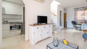 A modern kitchen with white cabinets, a built-in oven, and a flat-screen TV on a wooden countertop. - Holiday Apartment with Sea View, Shared Pool & Jacuzzi, Terraces, Garden & Wi-Fi (Gran Alacant)