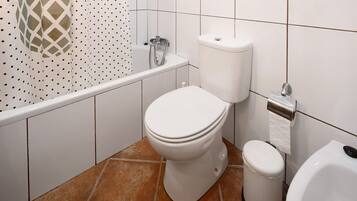 Un bagno con toilette, bidet e vasca da bagno.