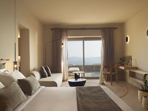 A modern hotel room with a large bed, a desk, a chair, and a view of the sea. - Collini Hotel Mykonos, WorldHotels Elite (Mykonos)