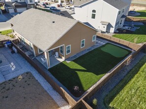 Una propiedad residencial con un amplio patio trasero, piscina y terraza cubierta.
