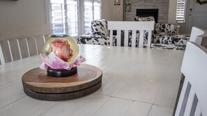 A modern living room with a round wooden table, a sofa with a black and white pattern, and a fireplace.
