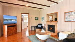 A living room with a television, fireplace, and seating area. - Wangi Waterfront Hideaway (Wangi Wangi)