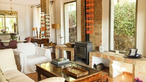 A cozy living room with a fireplace, comfortable seating, and a dining area. - Beautiful townhouse with garden, communal pool in Calpe, 4 km from the beach. (CALPE)