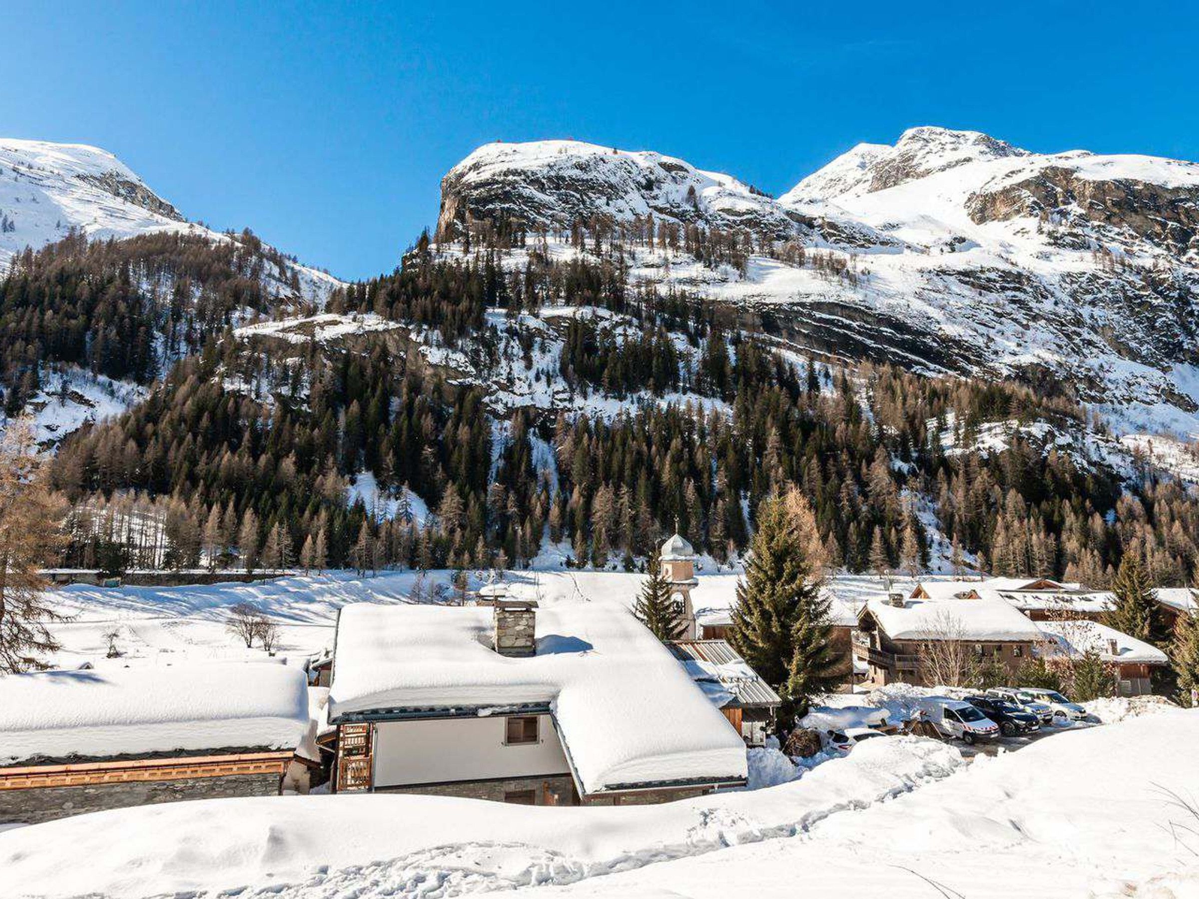 A snow-covered mountain village with traditional buildings and a clear sky.