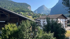 Un pueblo de montaña con edificios de madera tradicionales y una imponente montaña al fondo.