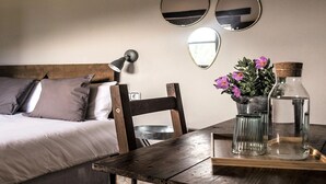 A bedroom with a bed, a wooden chair, a table with a vase of flowers, and three wall mirrors. - More from lárlequí - Entire farmhouse (Rojals)