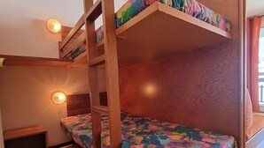 A bunk bed room with a wooden ladder, a small bench, and a wall-mounted light fixture. - Cozy studio with WIFI 50m from slopes - 4 ppl (Le Dévoluy)